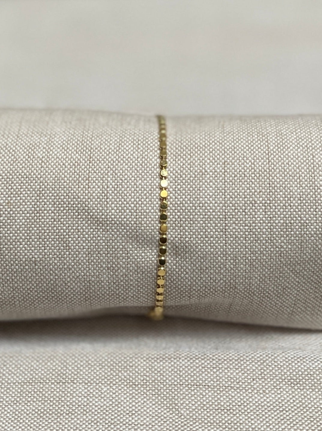 Image of bracelet. Chain Length: 7 inches Chain Type: Flat Bead Chain Thickness: 2 mm Clasp: Lobster Chain: 18k Gold-filled